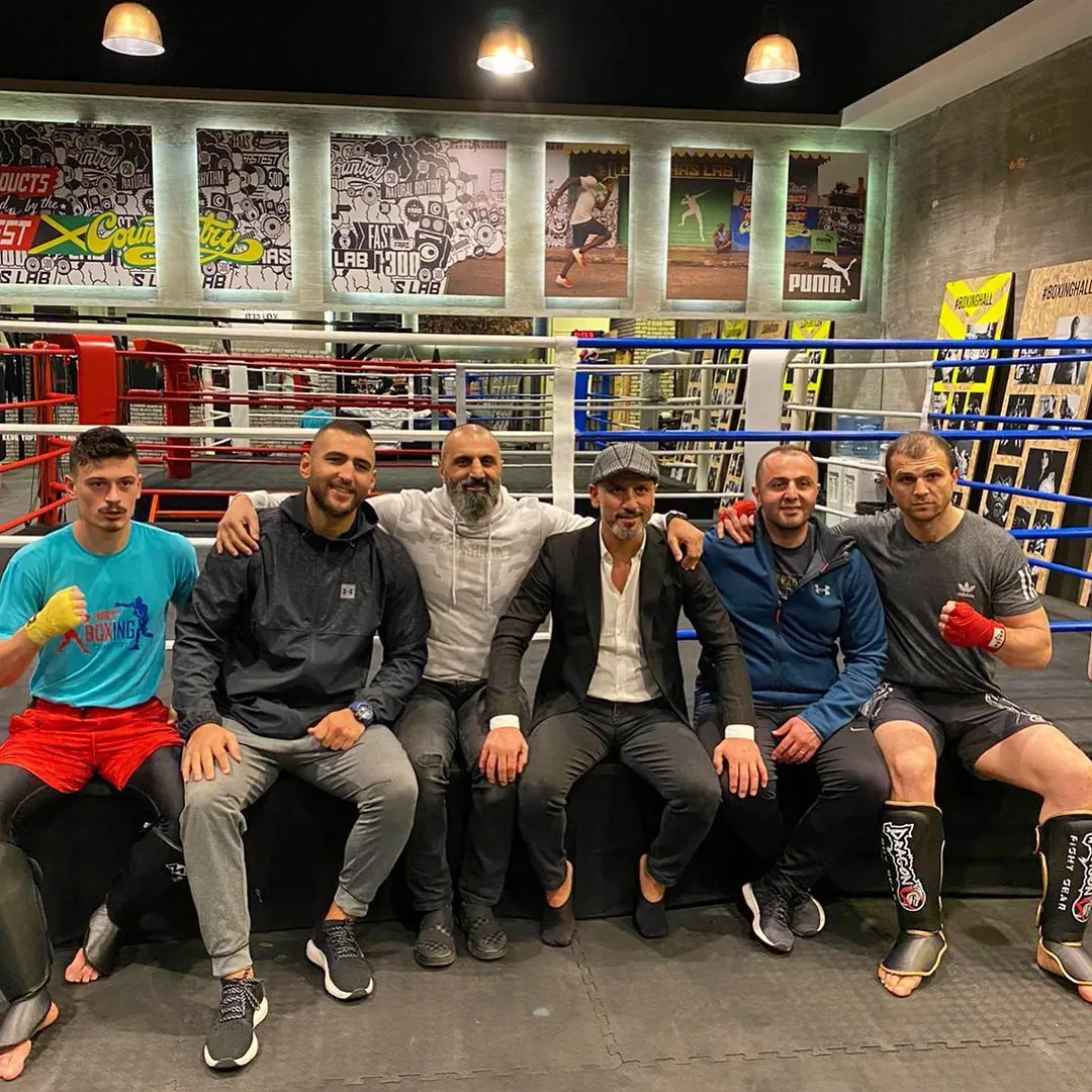 Boxinghall ringinin kenarında Birol Topuz ve salondan bir grup