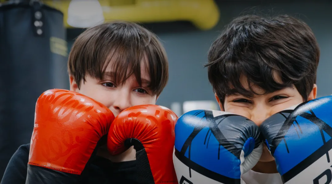 Boxinghall'da eldivenlerini takmış, gard almış iki çocuk